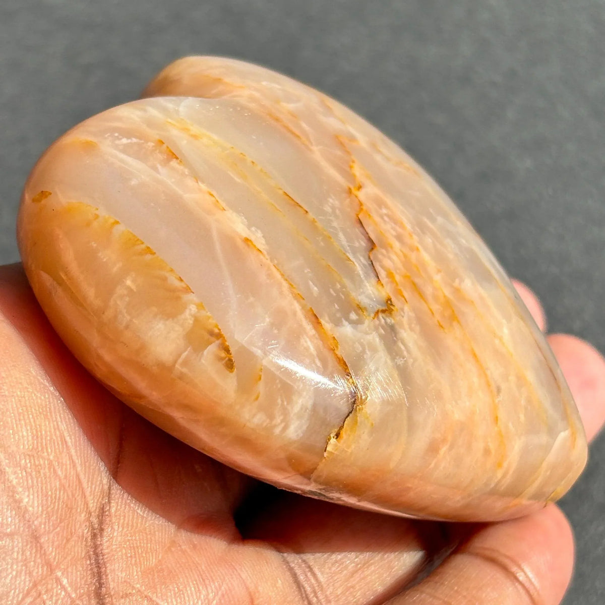 Peach Moonstone Heart Crystal Sculpture against a black background