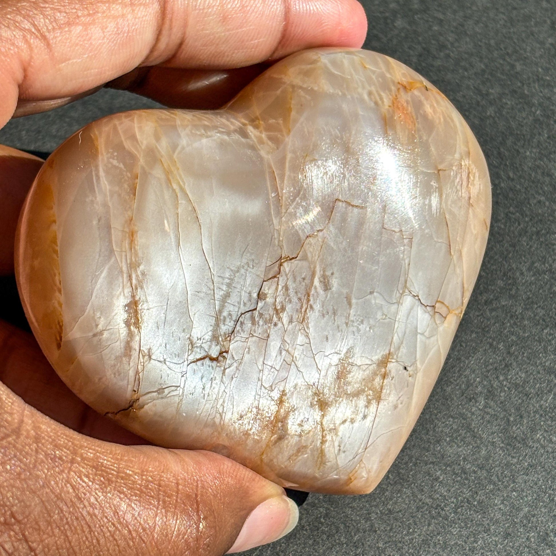 Peach Moonstone Heart Crystal Sculpture against a black background
