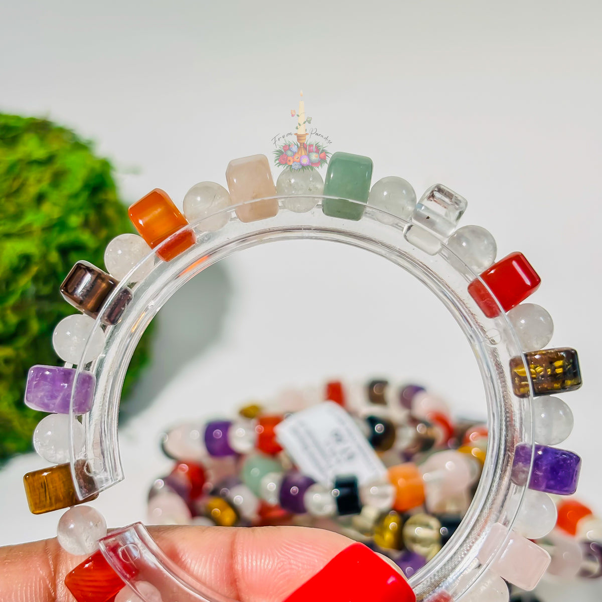 Multi-gemstone crystal bracelet with colorful healing stones on a clear display stand.