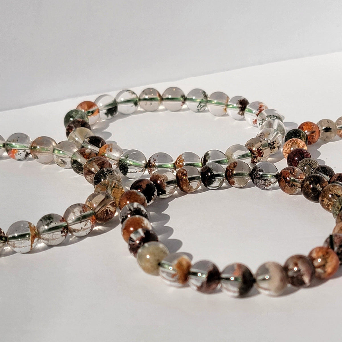 four garden quartz bracelets against white background