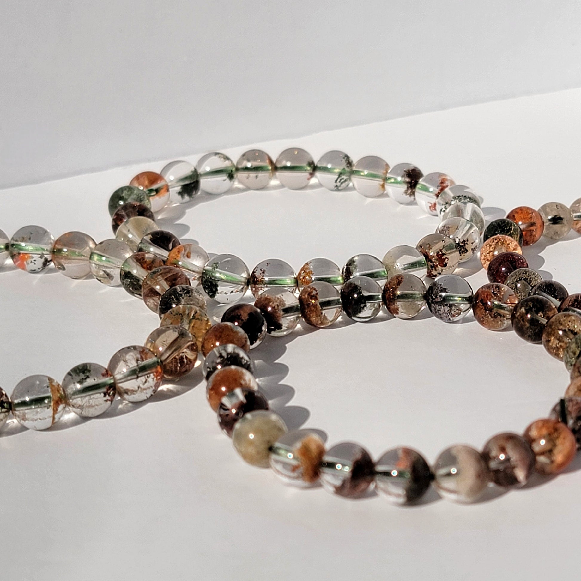 four garden quartz bracelets against white background