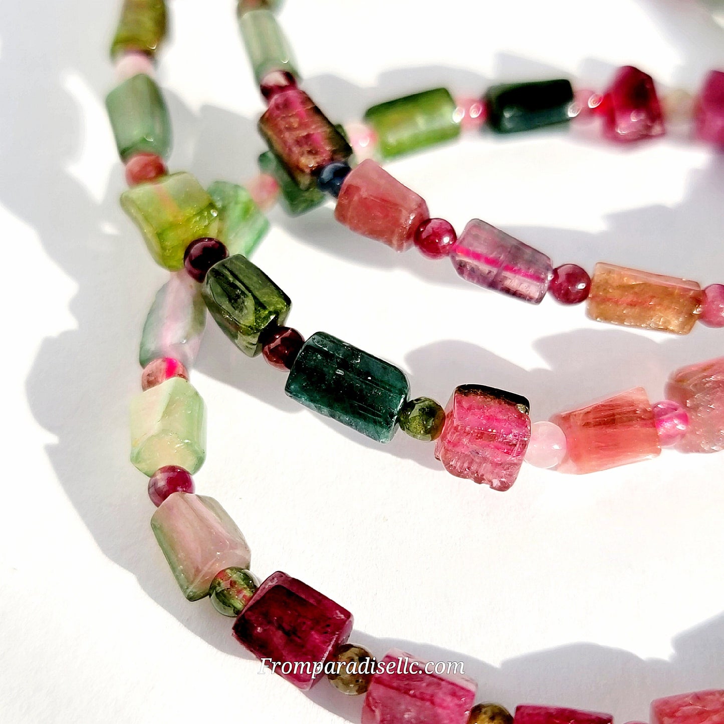 Close up of micro faceted square bicolour tourmaline beads highlighting the sharp cube cut and natural gemstone clarity.