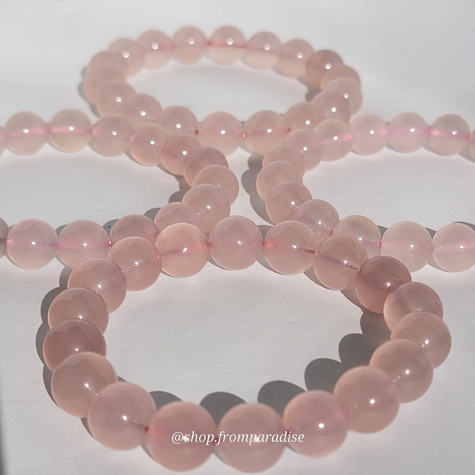 Rose Chalcedony Crystal Bracelet against white background in natural sunlight lighting