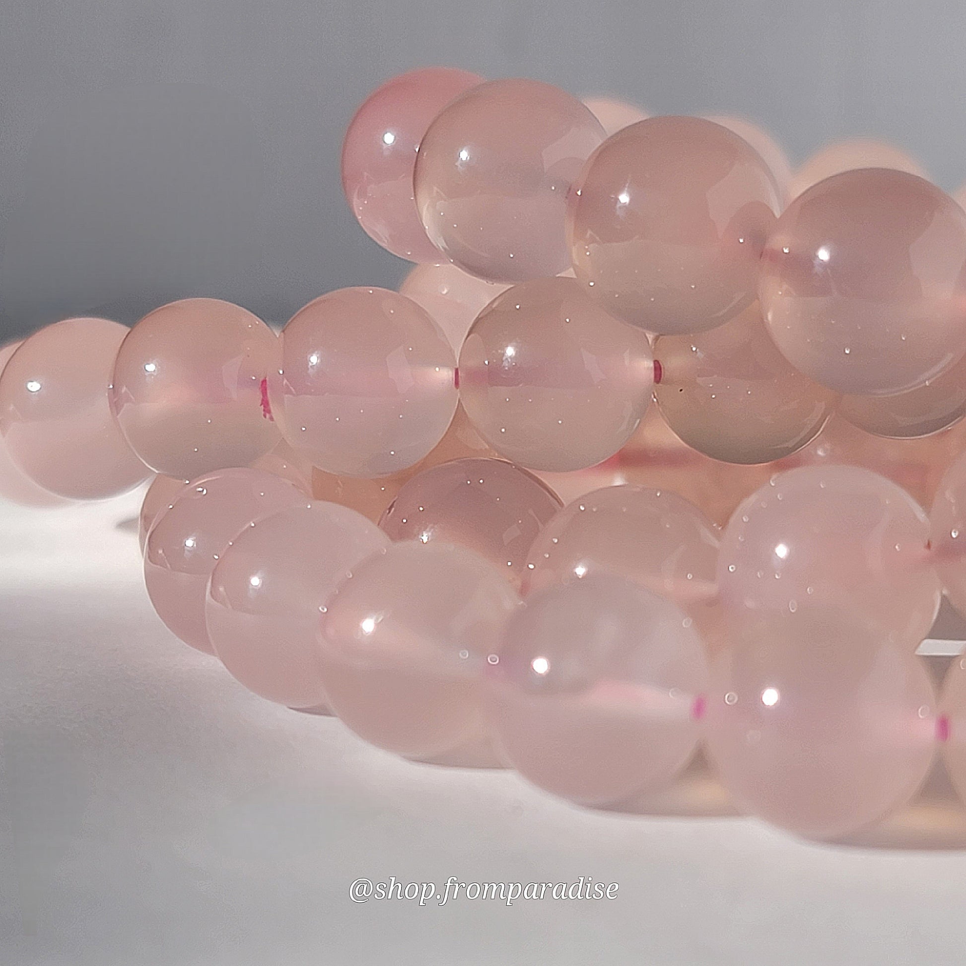 Rose Chalcedony Crystal Bracelet against white background in natural sunlight lighting