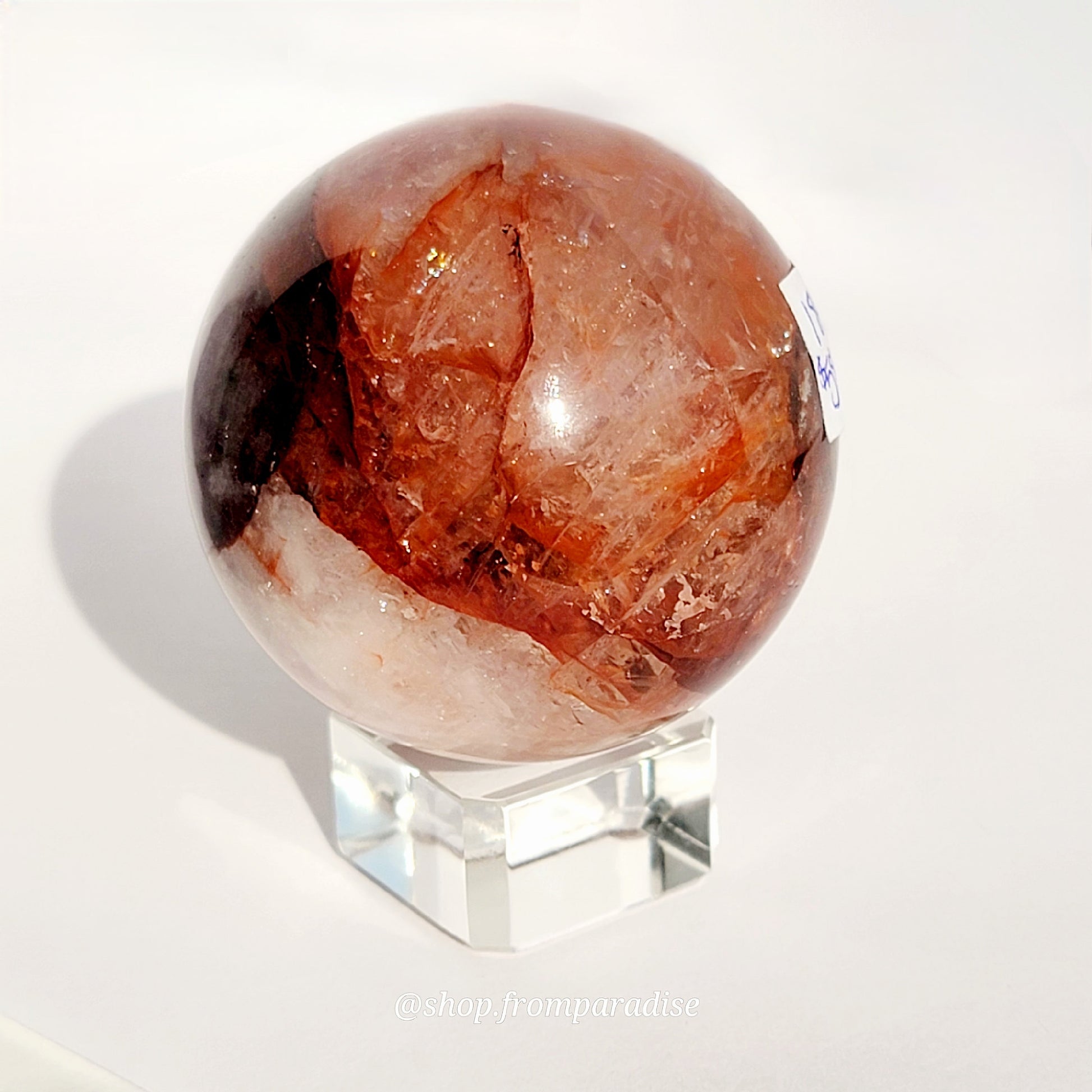 Fire Quartz Red Hematoid Sphere on glass sphere holder against white background