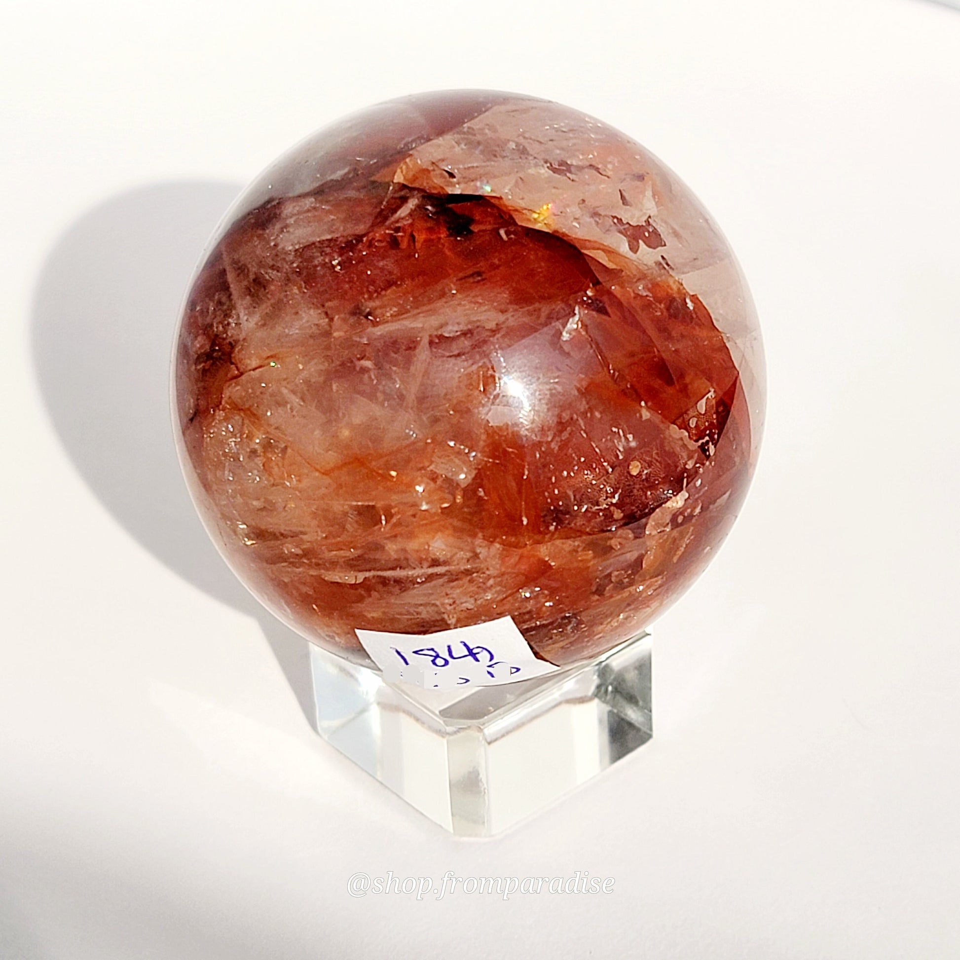 Fire Quartz Red Hematoid Sphere on glass sphere holder against white background