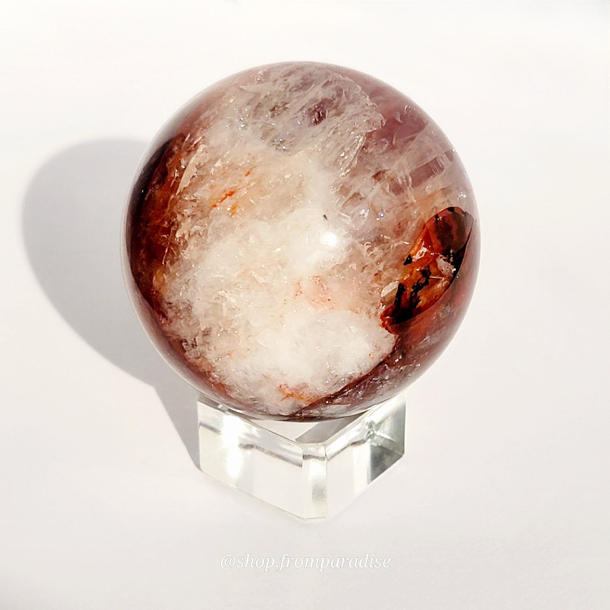 Fire Quartz Red Hematoid Sphere on glass sphere holder against white background