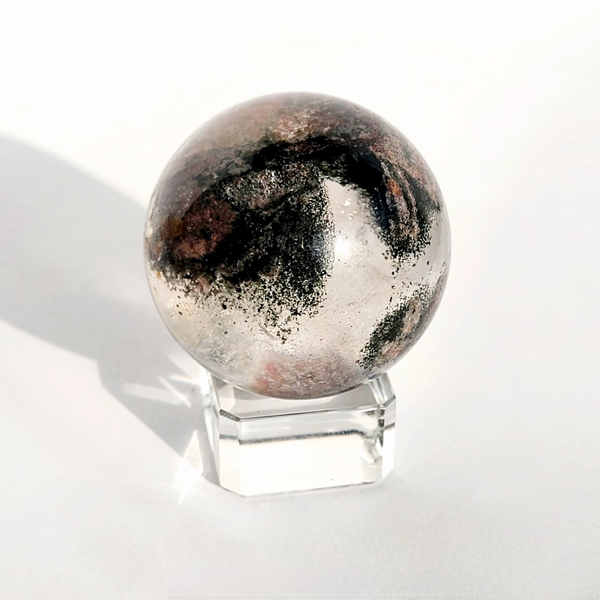 Garden Quartz Sphere on glass sphere stand against white background