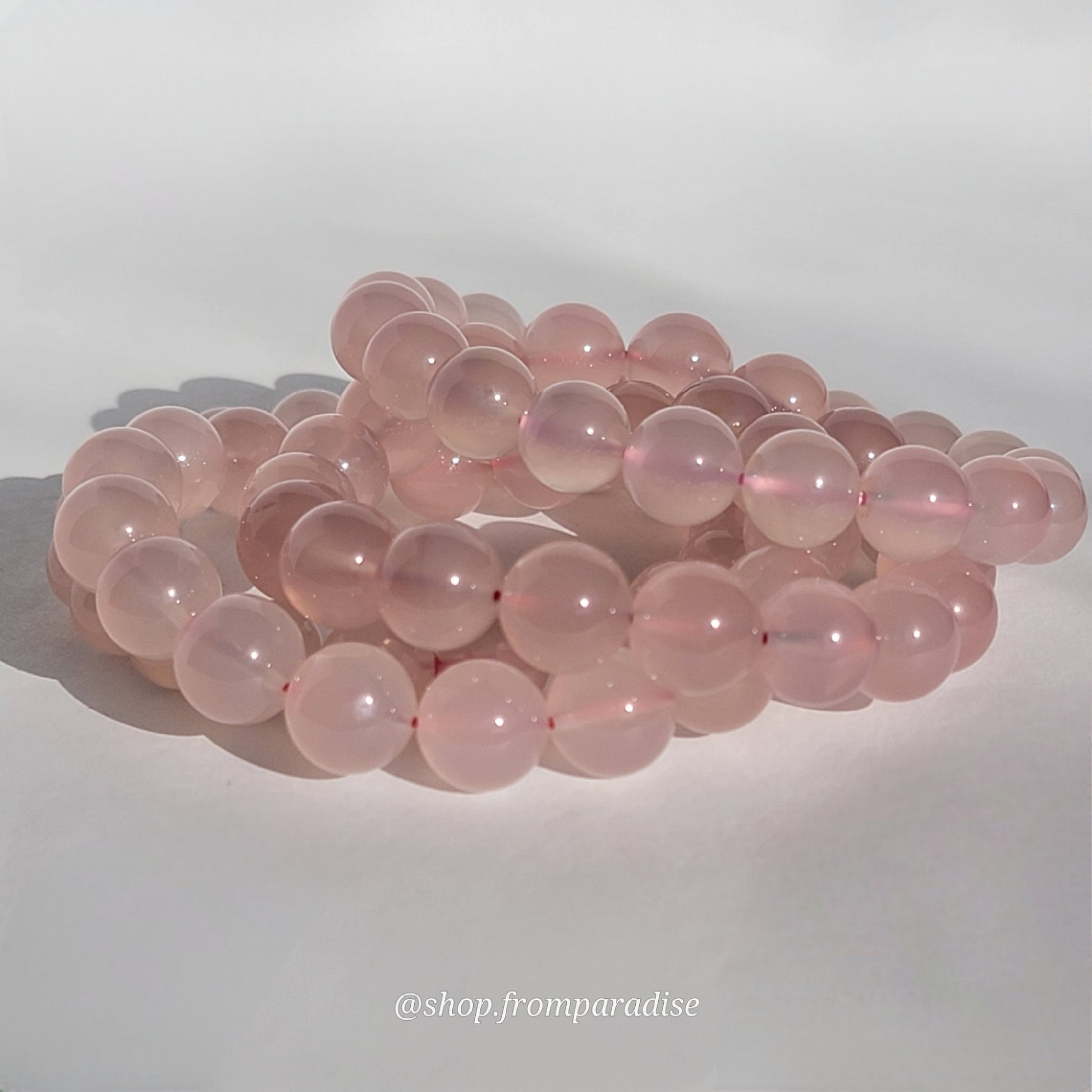 Rose Chalcedony Crystal Bracelet against white background in natural sunlight lighting