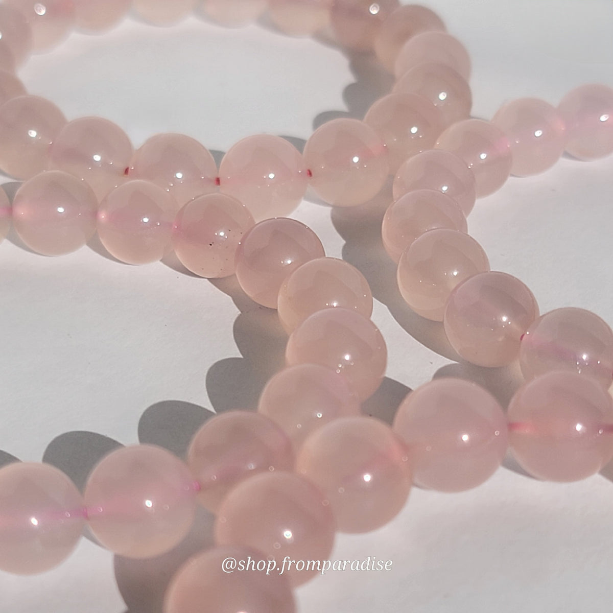Rose Chalcedony Crystal Bracelet against white background in natural sunlight lighting