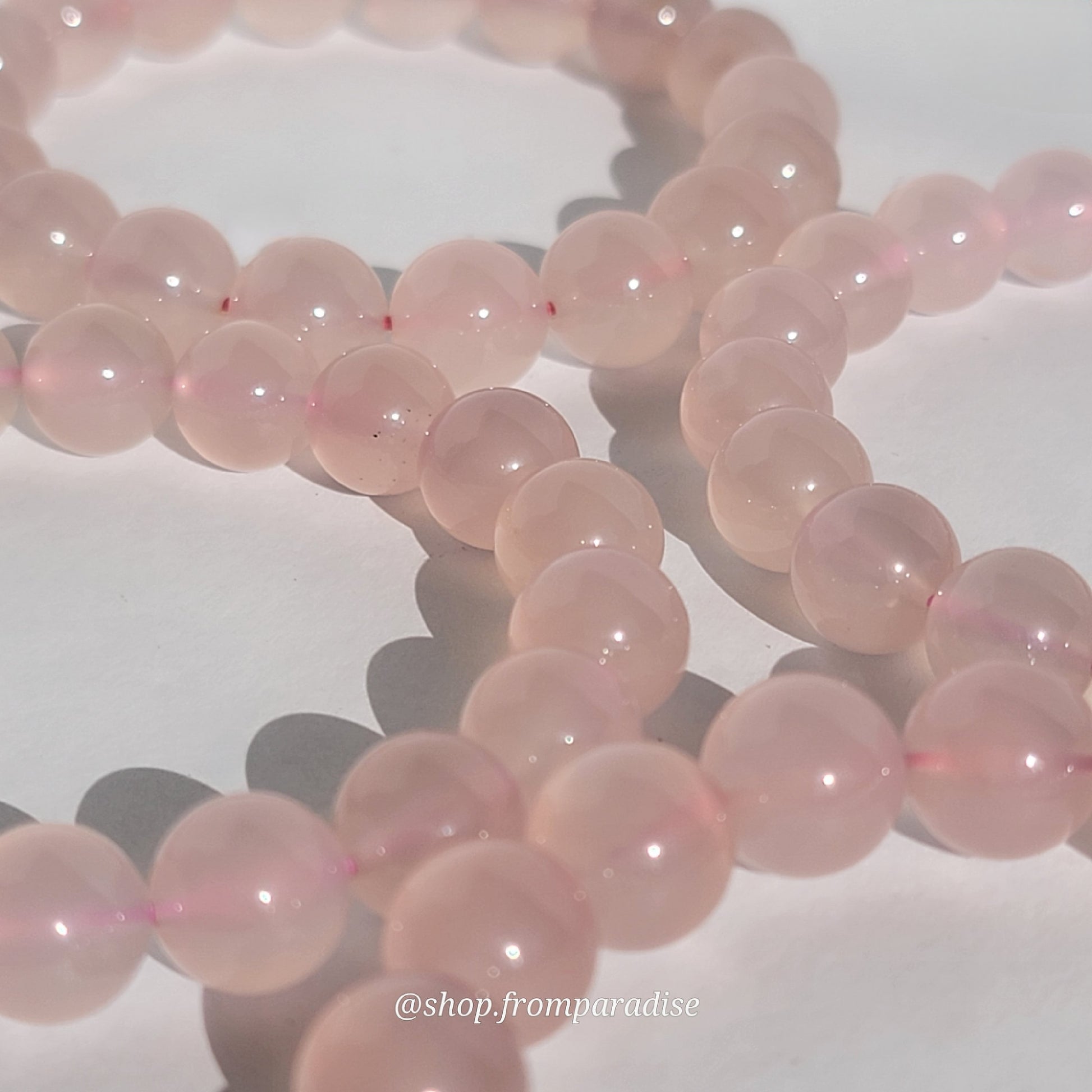 Rose Chalcedony Crystal Bracelet against white background in natural sunlight lighting