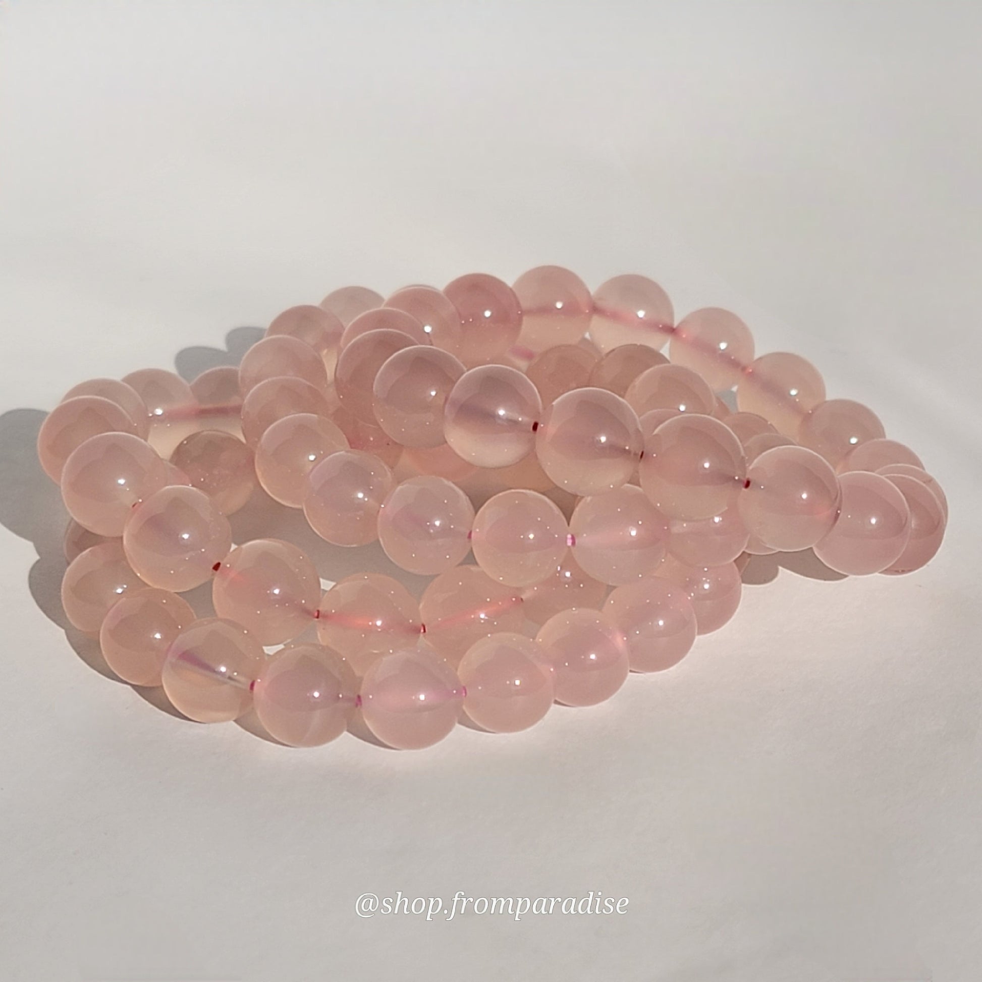 Rose Chalcedony Crystal Bracelet against white background in natural sunlight lighting