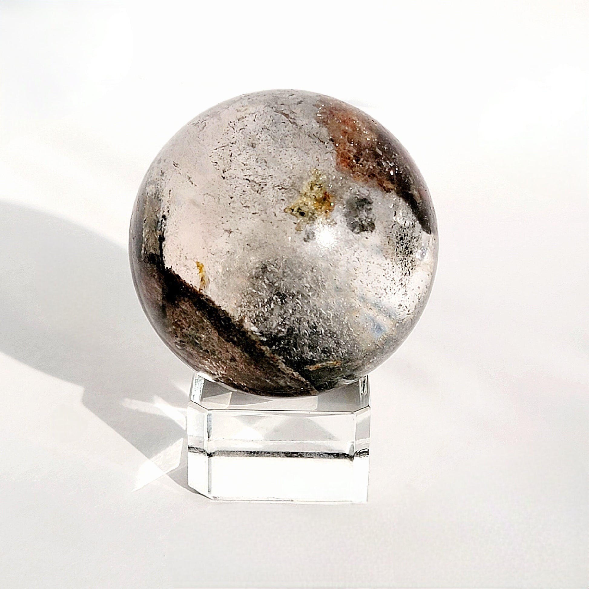 Garden Quartz Sphere on glass sphere stand against white background