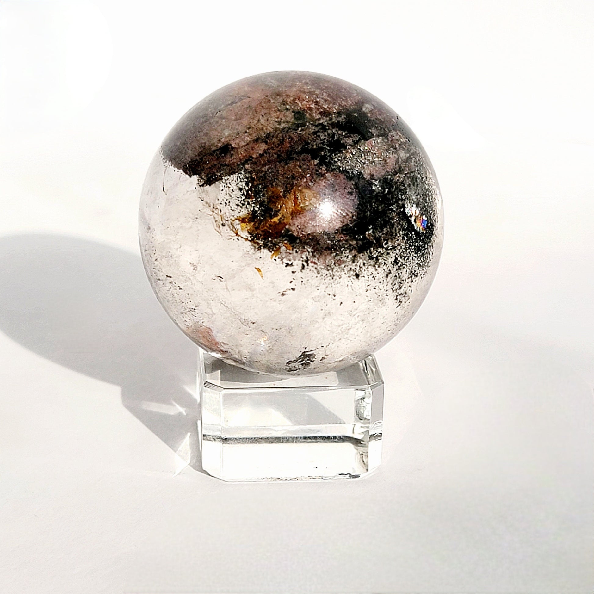Garden Quartz Sphere on glass sphere stand against white background