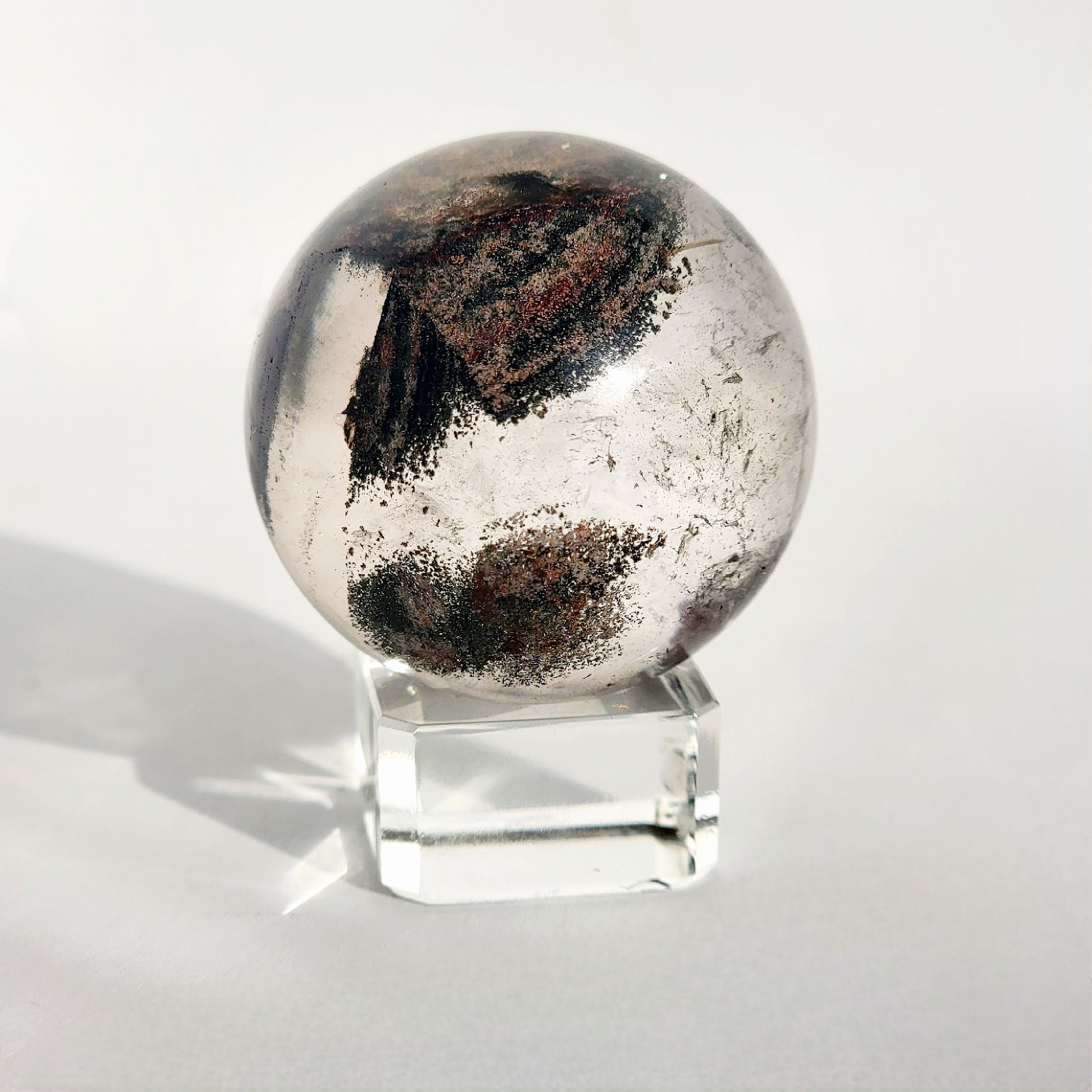 Garden Quartz Sphere on glass sphere stand against white background