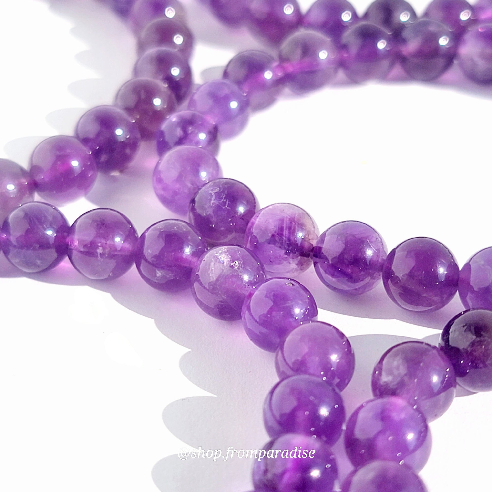 close up of amethyst handmade bracelet beads on a white background