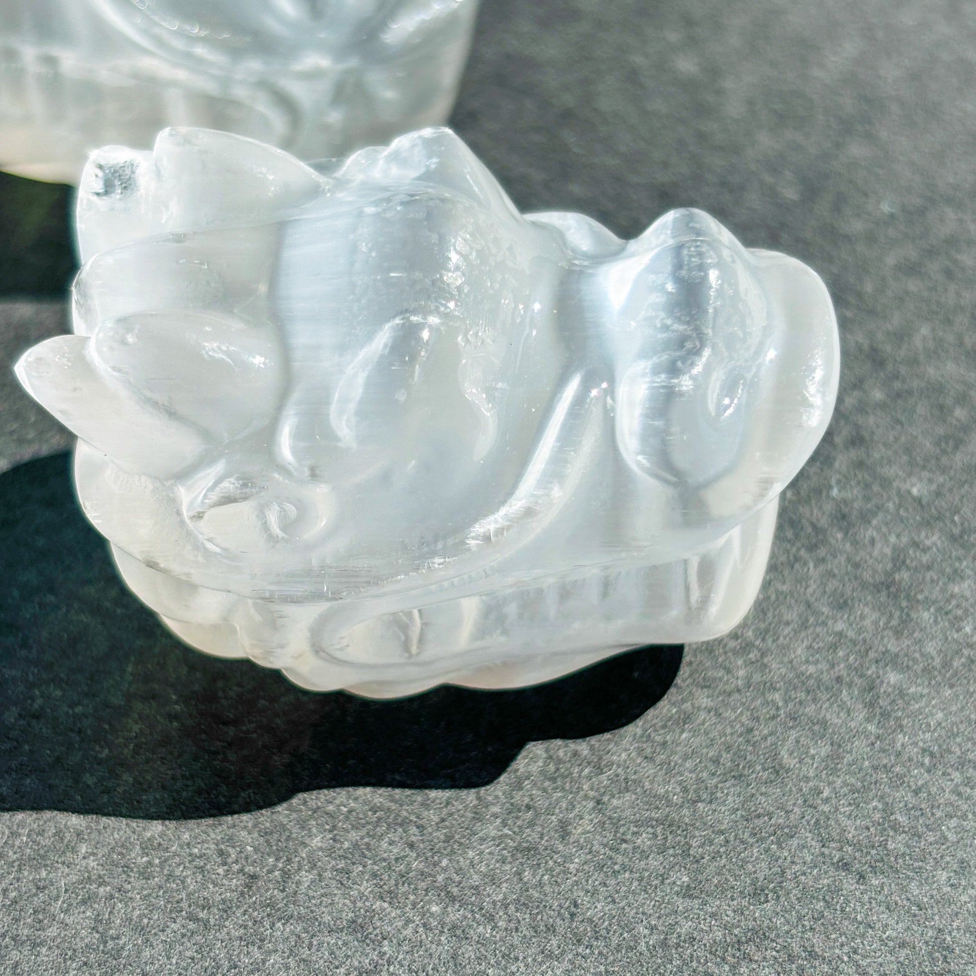 Selenite Oriental Dragon Crystal Sculpture against a black background