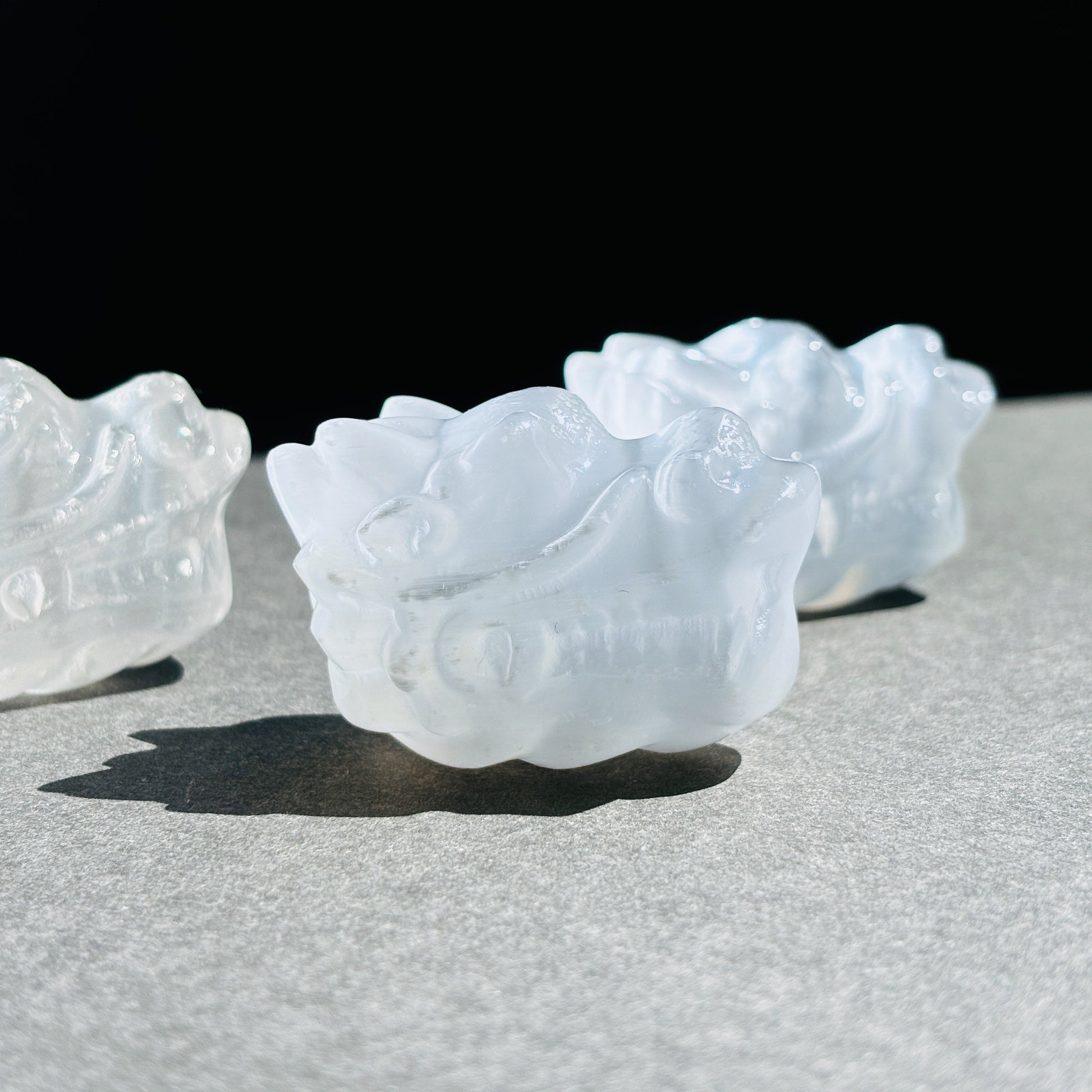 Selenite Oriental Dragon Crystal Sculpture against a black background