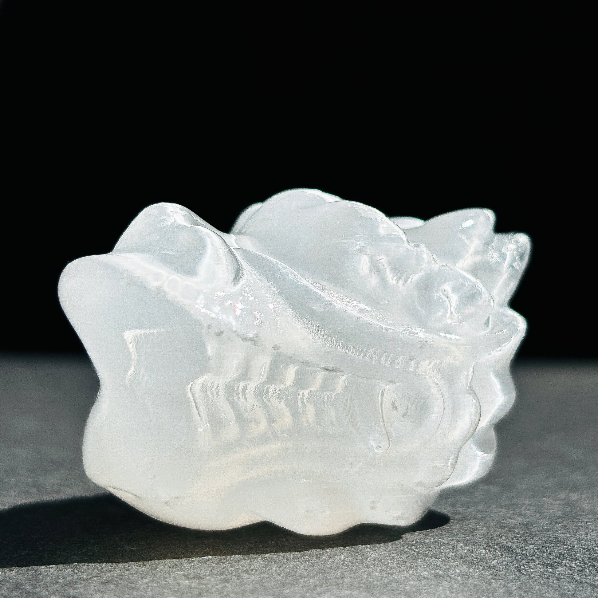 Selenite Oriental Dragon Crystal Sculpture against a black background