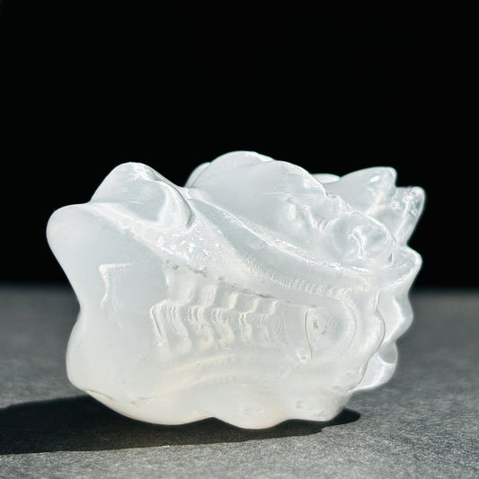 Selenite Oriental Dragon Crystal Sculpture against a black background