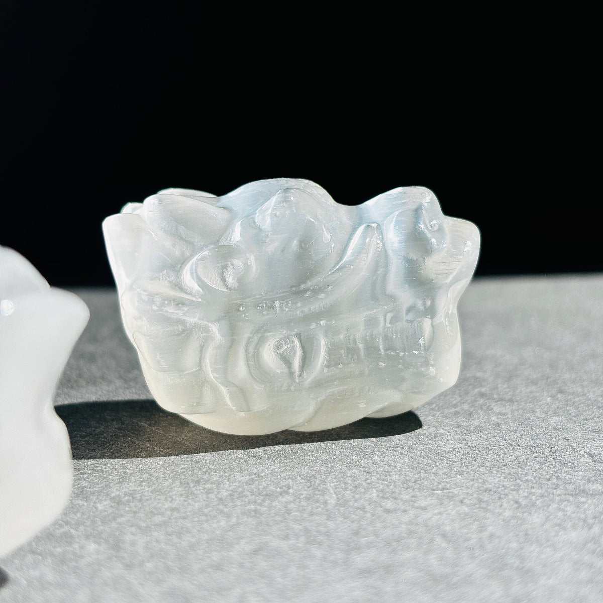 Selenite Oriental Dragon Crystal Sculpture against a black background