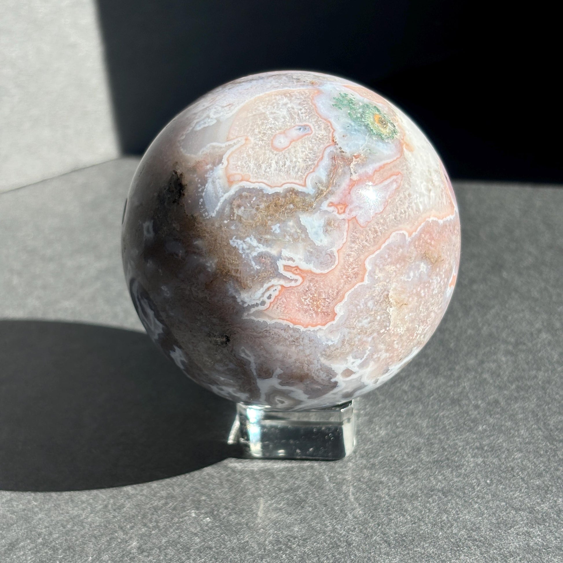 Druzy Pink Moss Agate Crystal Sphere against a black background