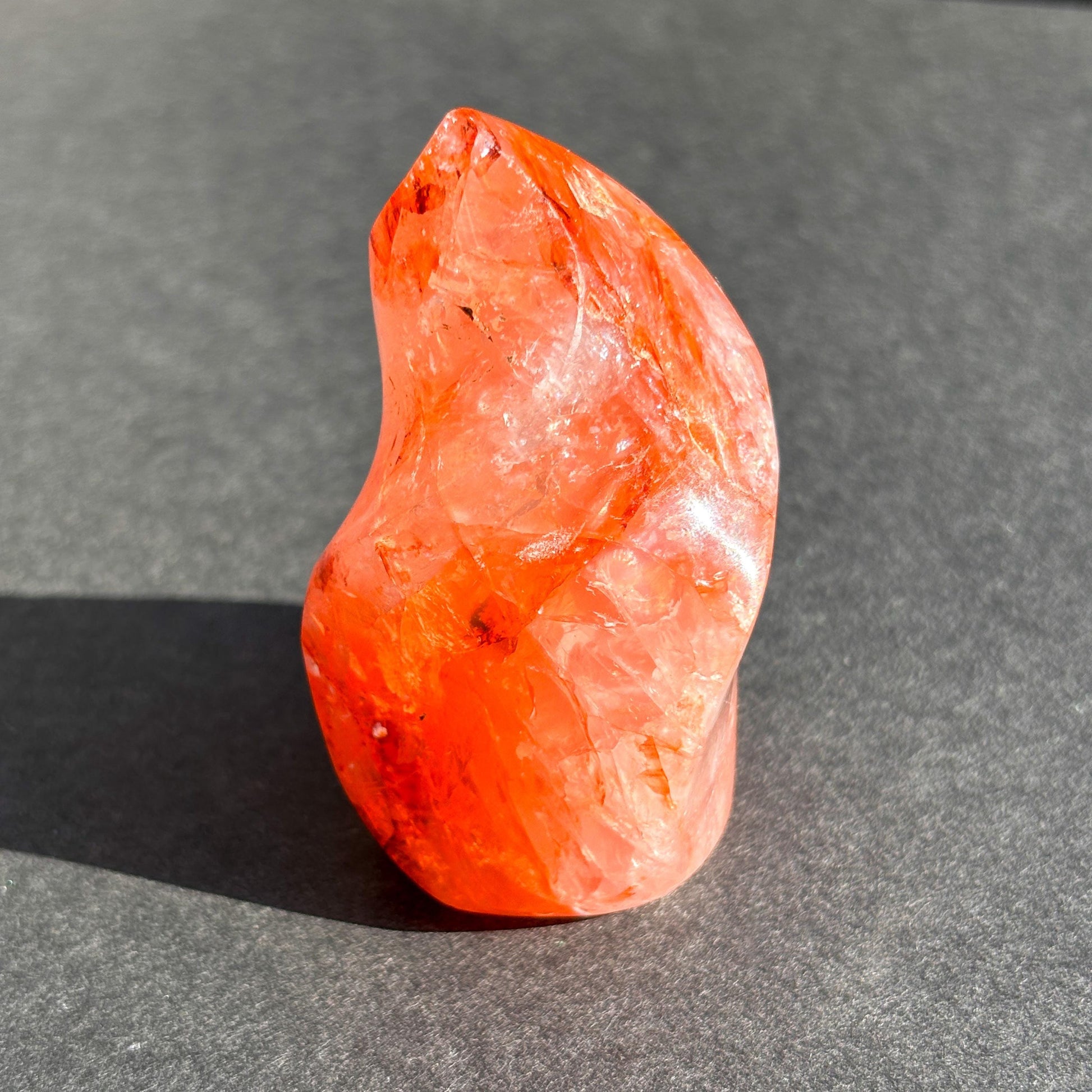 Fire Quartz Red Hematoid Crystal Flame Sculpture against a black background