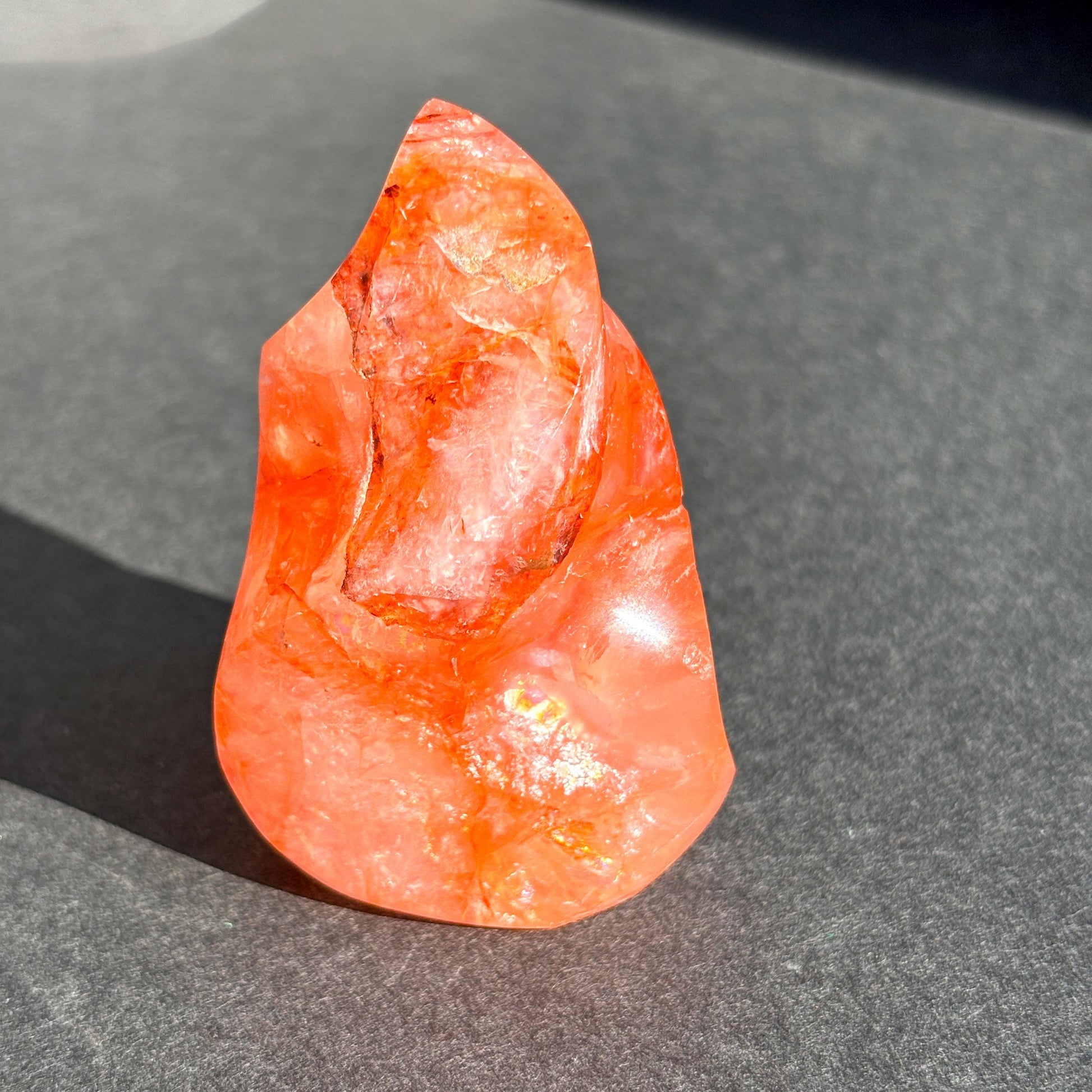 Fire Quartz Red Hematoid Crystal Flame Sculpture against a black background