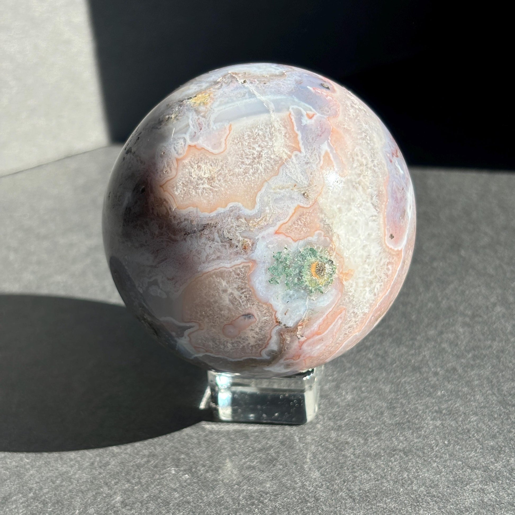Druzy Pink Moss Agate Crystal Sphere against a black background