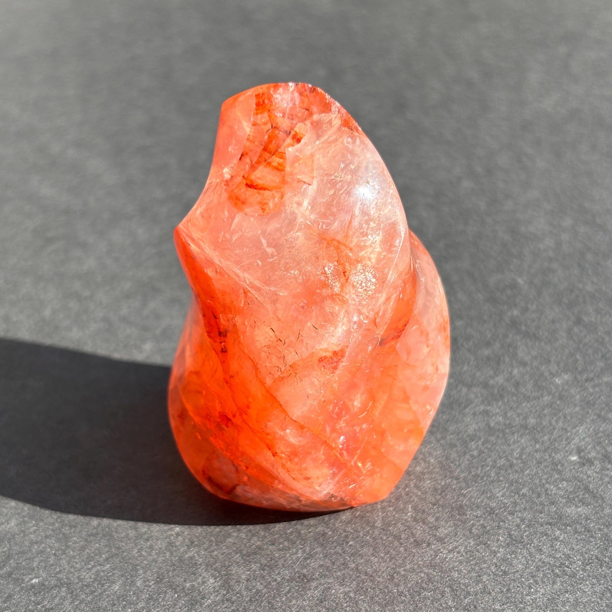 Fire Quartz Red Hematoid Crystal Flame Sculpture against a black background
