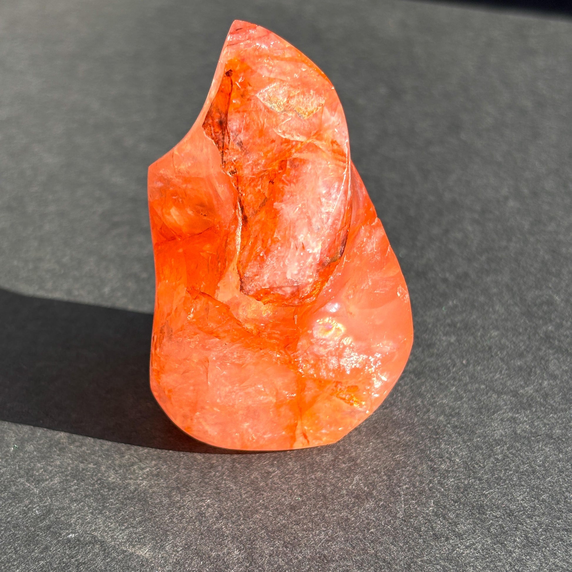 Fire Quartz Red Hematoid Crystal Flame Sculpture against a black background