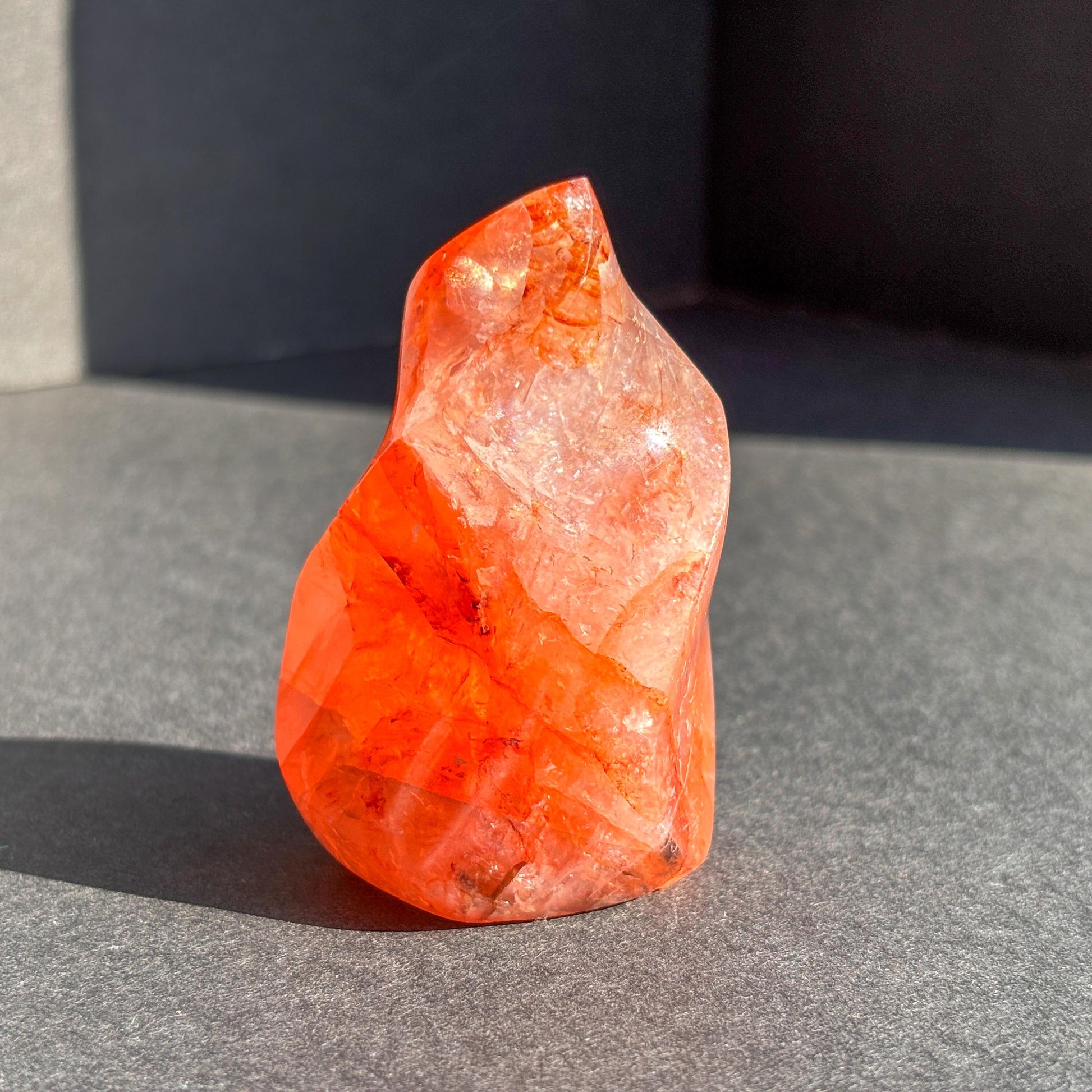 Fire Quartz Red Hematoid Crystal Flame Sculpture against a black background