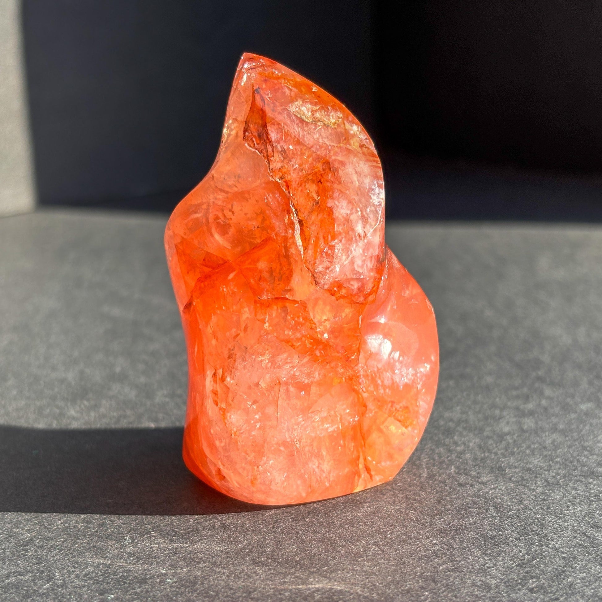 Fire Quartz Red Hematoid Crystal Flame Sculpture against a black background