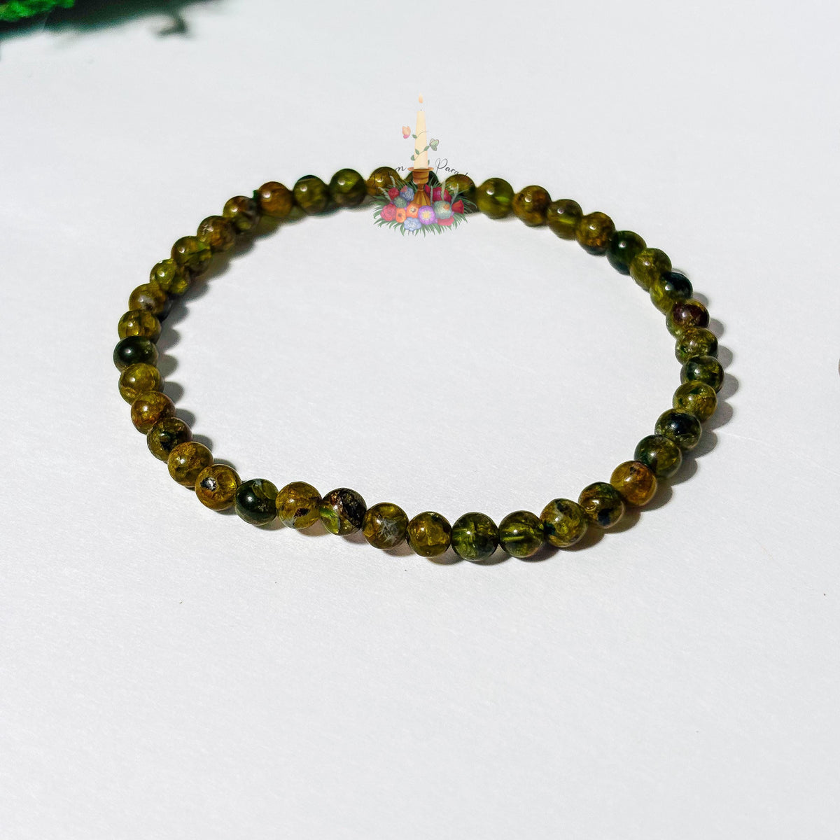 Handmade 4mm genuine peridot beaded stretch bracelet featuring small round vibrant green gemstone beads against a white background. ideal as a minimalist August birthstone jewelry gift.