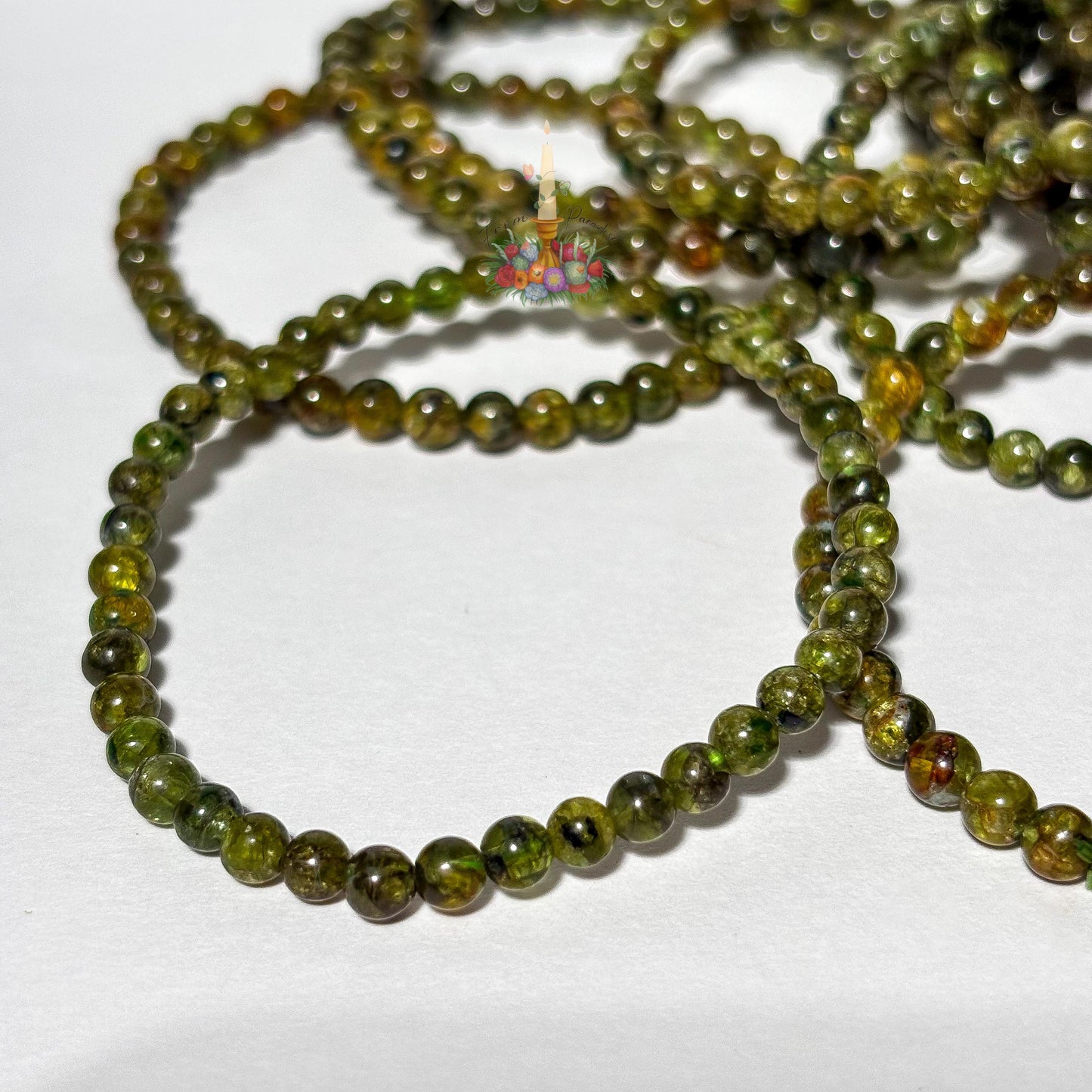 Handmade 4mm genuine peridot beaded stretch bracelet featuring small round vibrant green gemstone beads against a white background. ideal as a minimalist August birthstone jewelry gift.