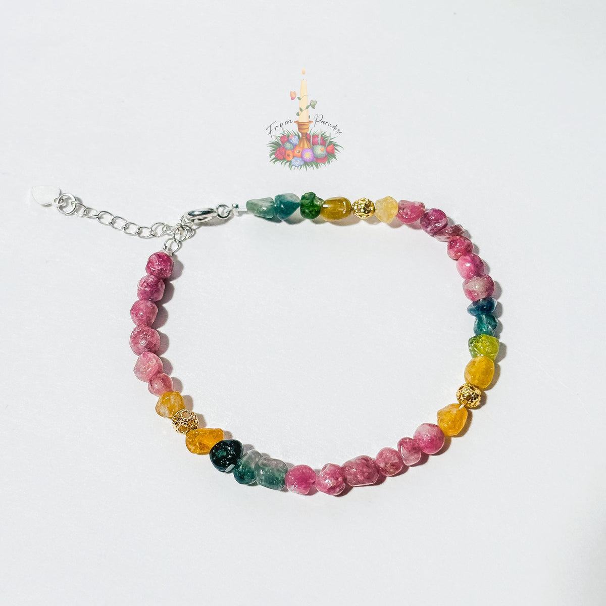 Handmade gemstone bracelet made with multi-colored tourmaline chip beads in shades of pink, yellow, teal, and green, accented with gold textured spacer beads and a silver adjustable clasp chain.