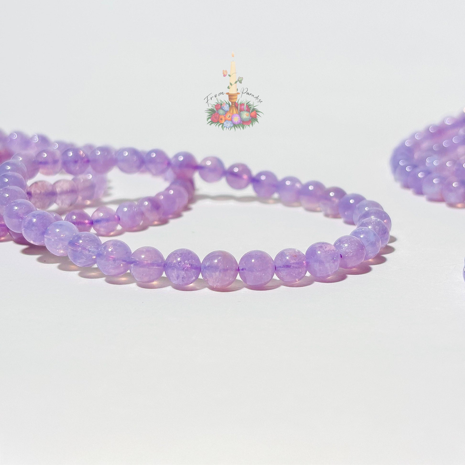 Lavender moon quartz crystal bracelet close up against white background.
