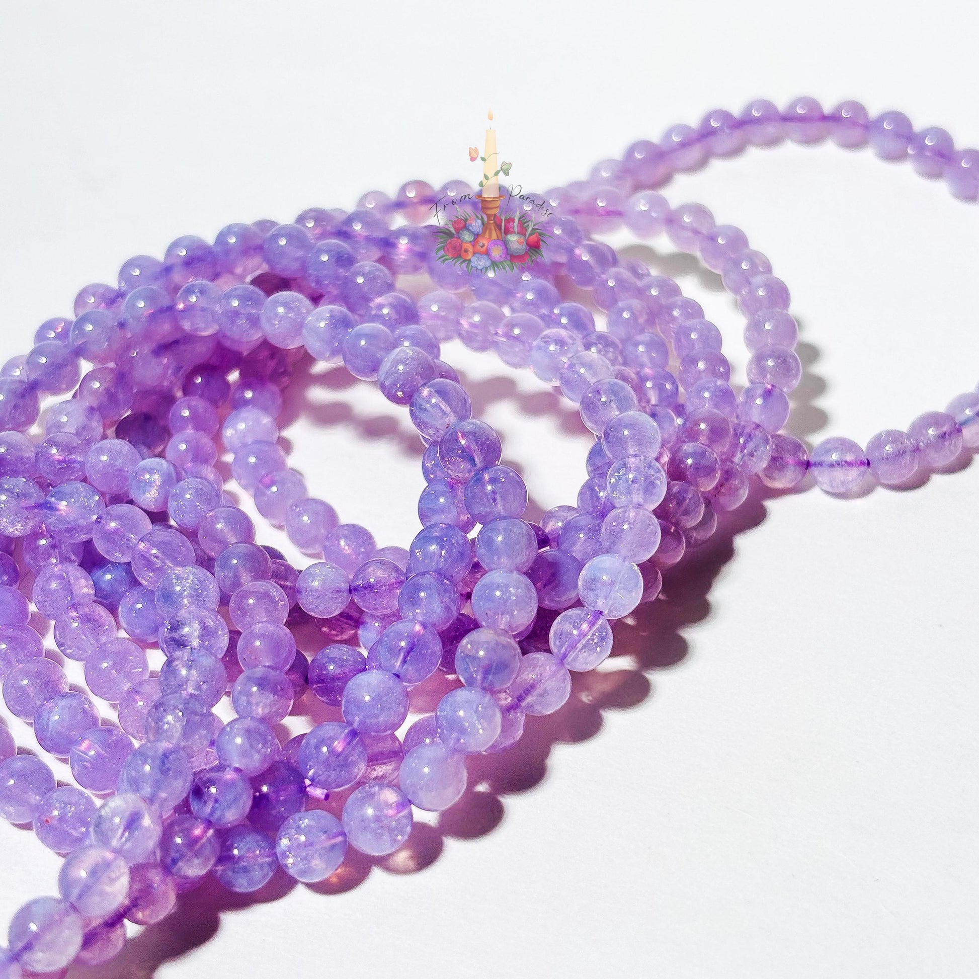 Lavender moon quartz crystal bracelets close up against white background.